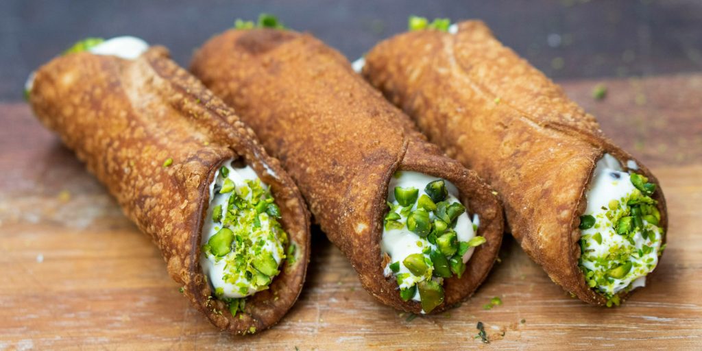 cannolo wypełnione ricottą i posypane pistacjami – klasyczny deser z Sycylii